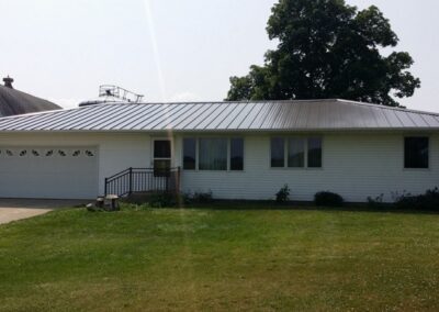 a white house with a metal roof and a garage